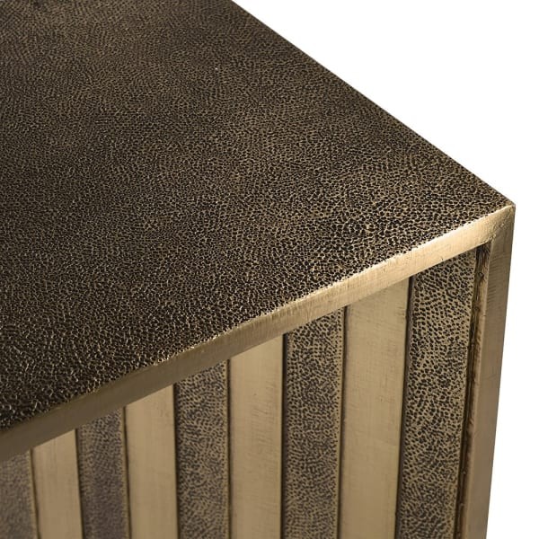 Close-up of textured and smooth brass finish on console table