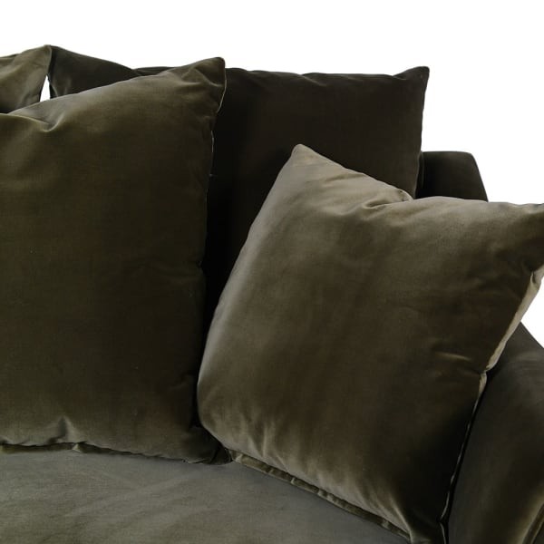 Large green velvet armchair with comfortable cushions