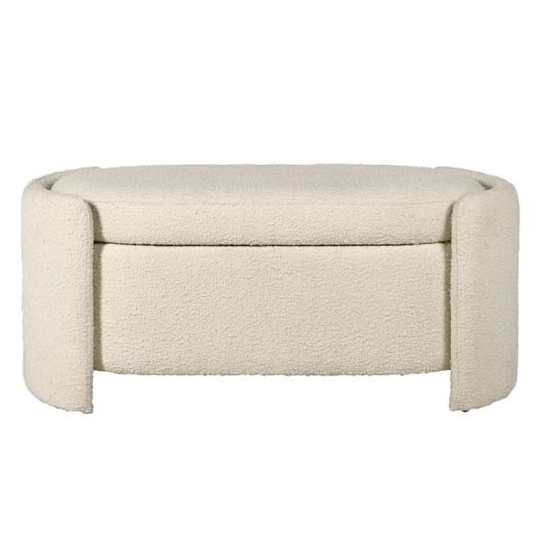 Upholstered bouclé storage bench at the foot of the bed in a modern bedroom