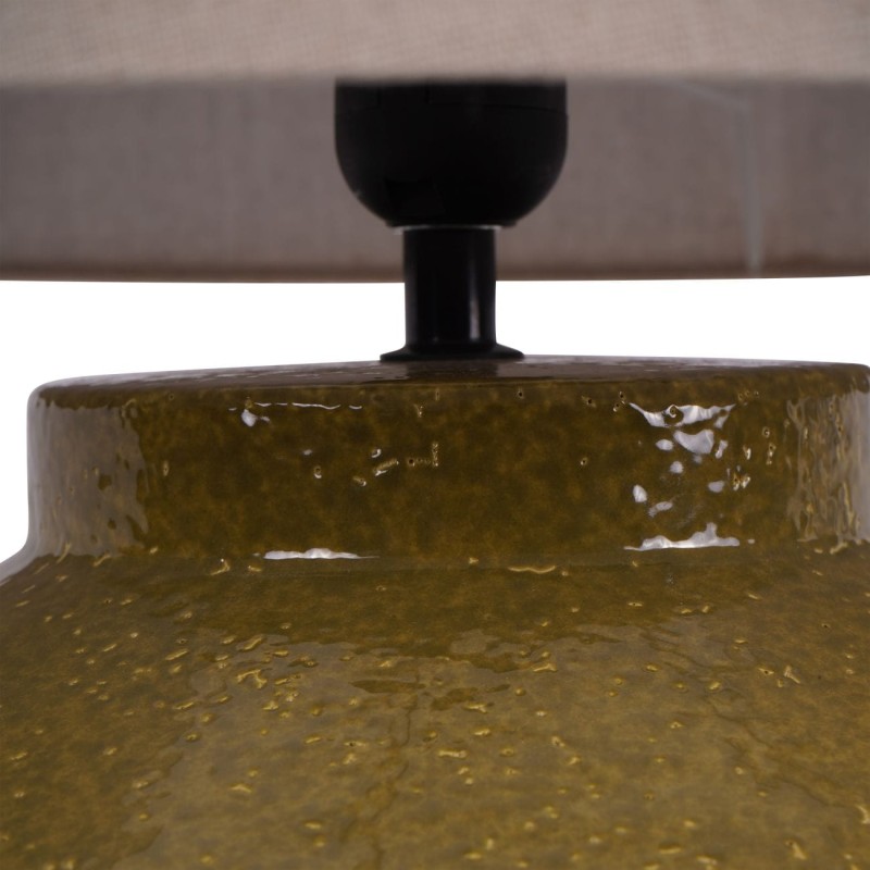 Green table lamp displayed beside a sofa