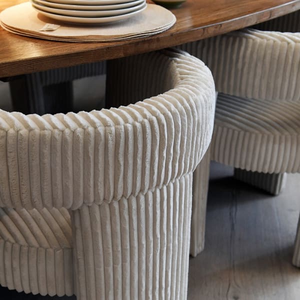 Fully upholstered three-legged dining chair in cream