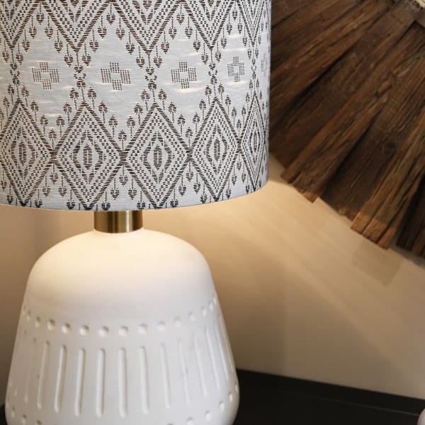 White ceramic table lamp with patterned linen shade and gold accents