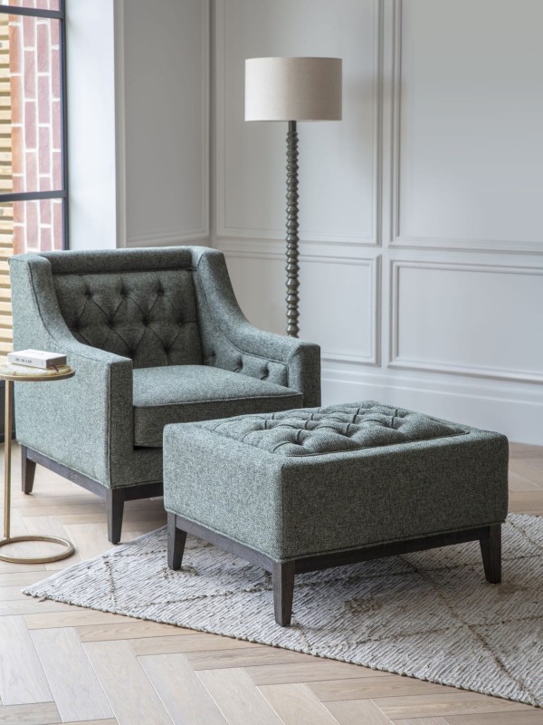 Green footstool with decorative buttons and stitching