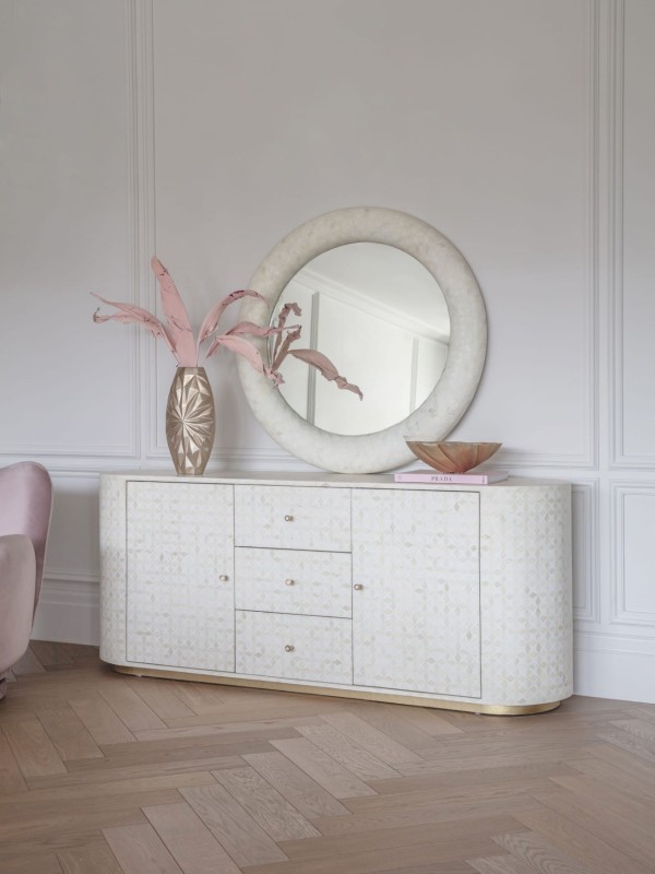 Round decorative mirror above a sideboard or console table