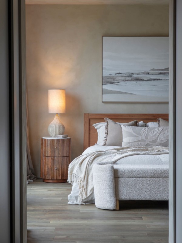 Rounded wooden bedside table with marble top