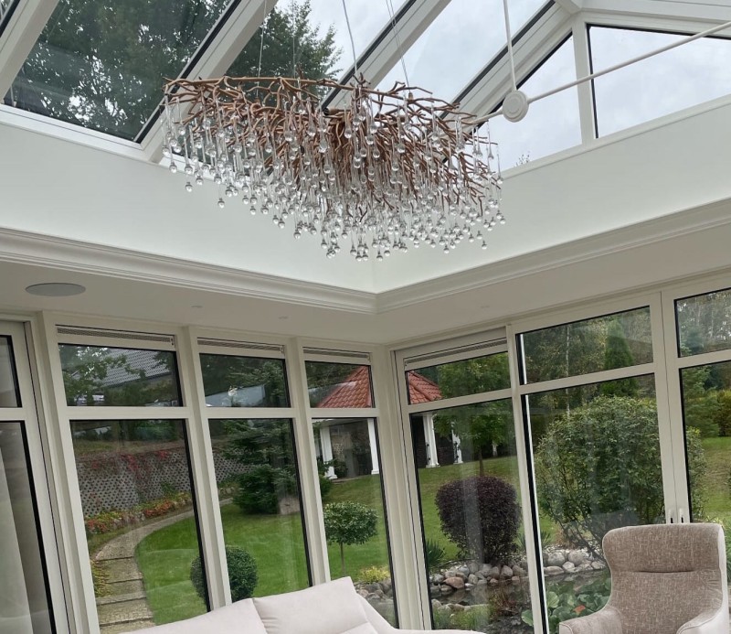 Gold Innovation chandelier with sculptural frame and glass droplets