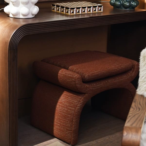 Designer rust vanity stool with sculptural curved silhouette