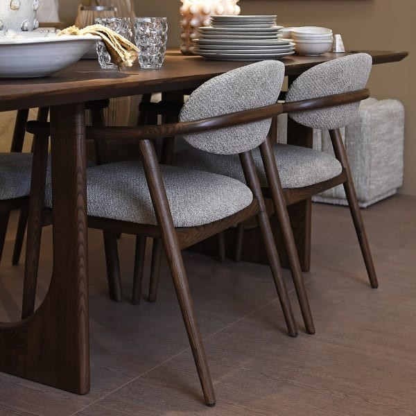 Two Berlin beige upholstered dining chairs at a dark wooden dining table