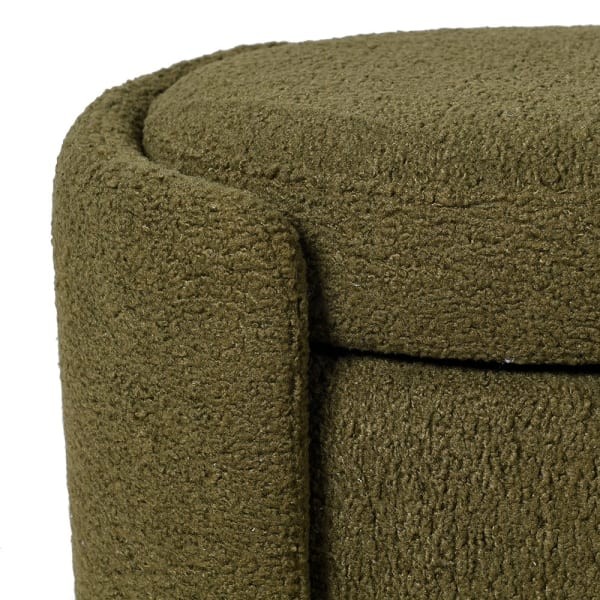 Bouclé upholstered storage bench in olive green at the foot of a bed