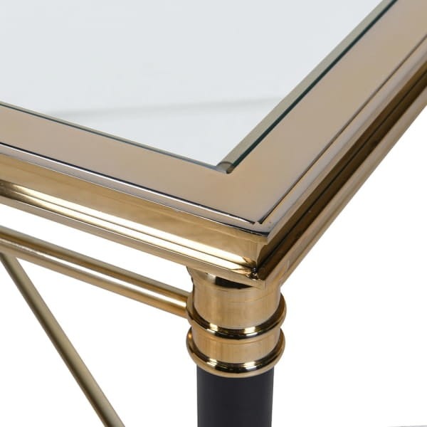 Foo glass coffee table with gold and black metal frame and crossed stretcher detail