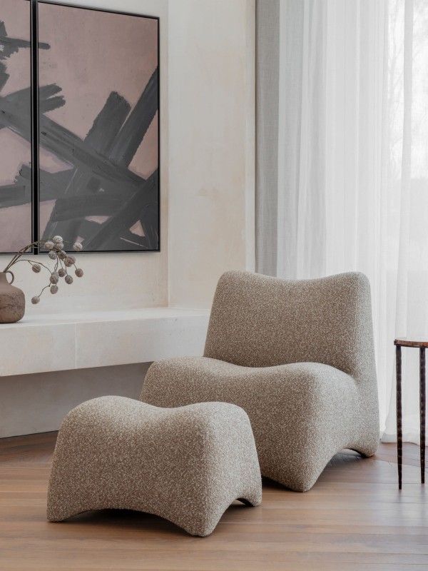 Modal bouclé armchair with footstool in beige and brown. Modern lounge chair.