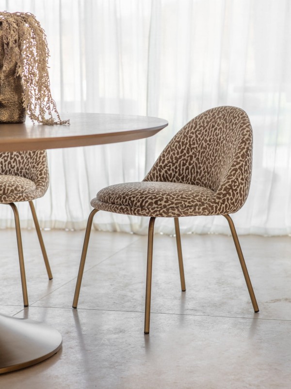 Animal Print chair with patterned upholstery and elegant gold legs. A bold accent piece for modern interiors.