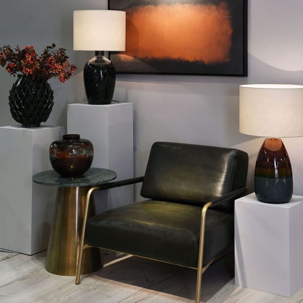 Green leather lounge chair with a brass-toned steel frame