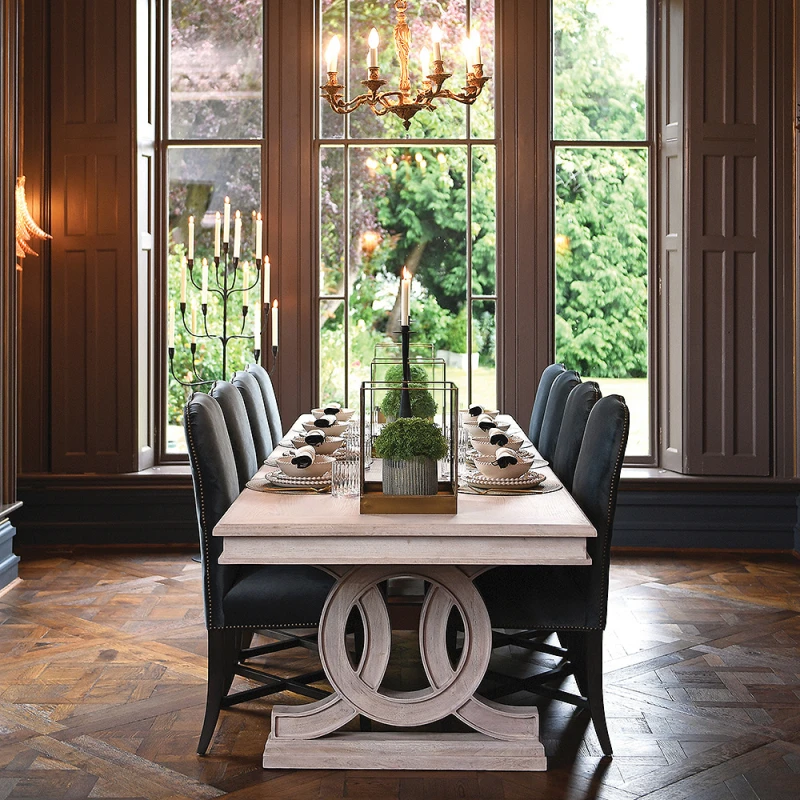 Large pale wood dining table with a sculptural base