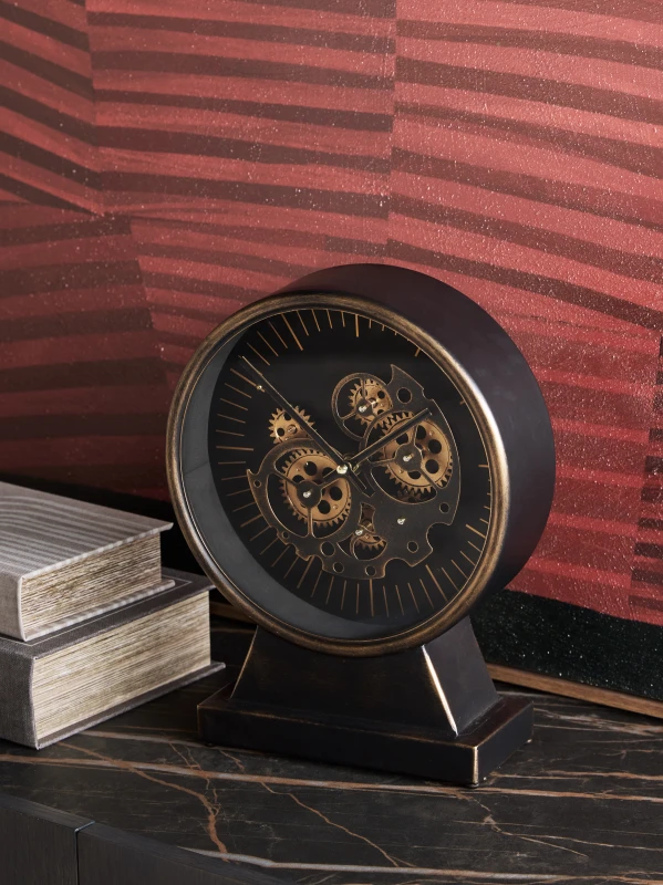 Black and gold clock with visible moving gears