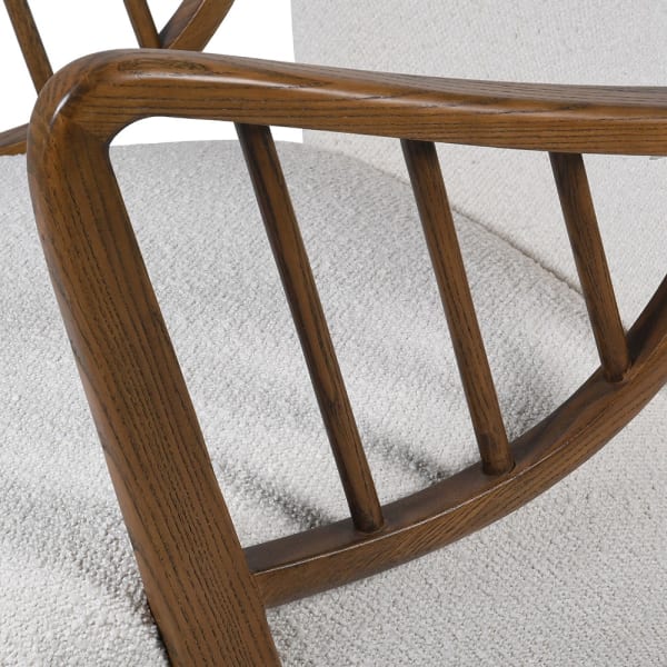 Curved wooden armrest and spindle detail of the Lariat Bouclé Armchair