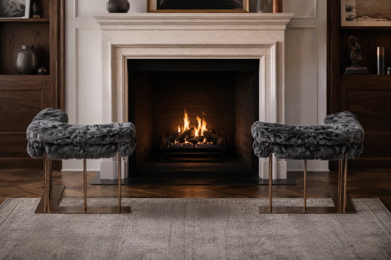 Raven sheepskin fire fenders styled beside a limestone fireplace