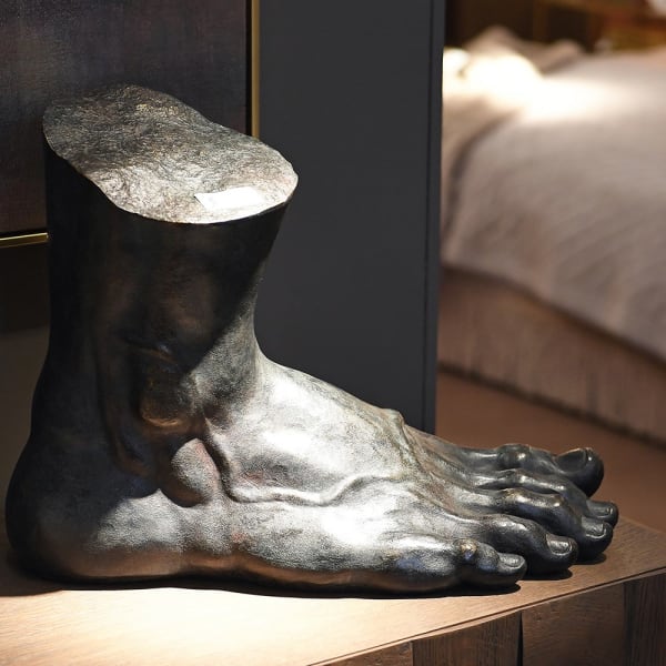 Piede Dark foot sculpture displayed on a wooden console