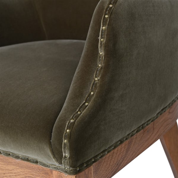 Olive velvet upholstery and decorative stud detailing on the dining chair