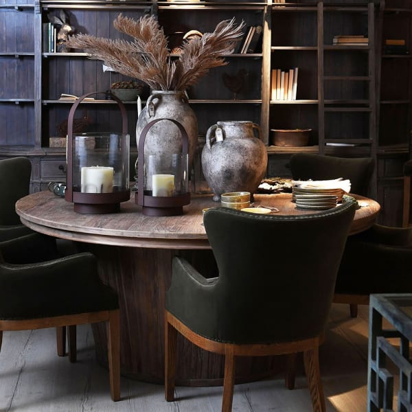 Olive green dining chairs around a round wooden table in an elegant dining room