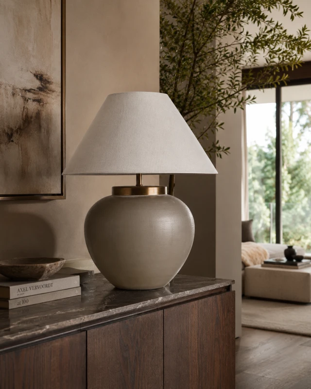 Fritzovia S smoked glass table lamp styled on a dark wood sideboard in a refined neutral living room