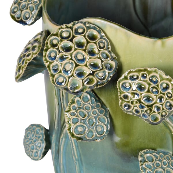 Close-up of raised lotus seed head detailing on green ceramic vase
