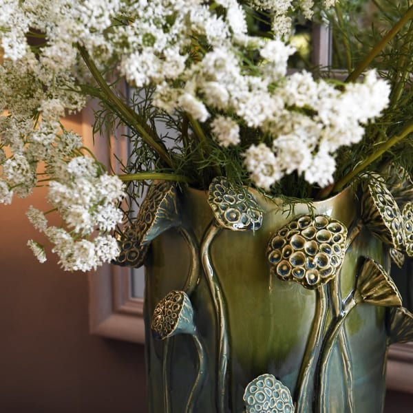 Lotus green ceramic vase styled with white flowers on an elegant console