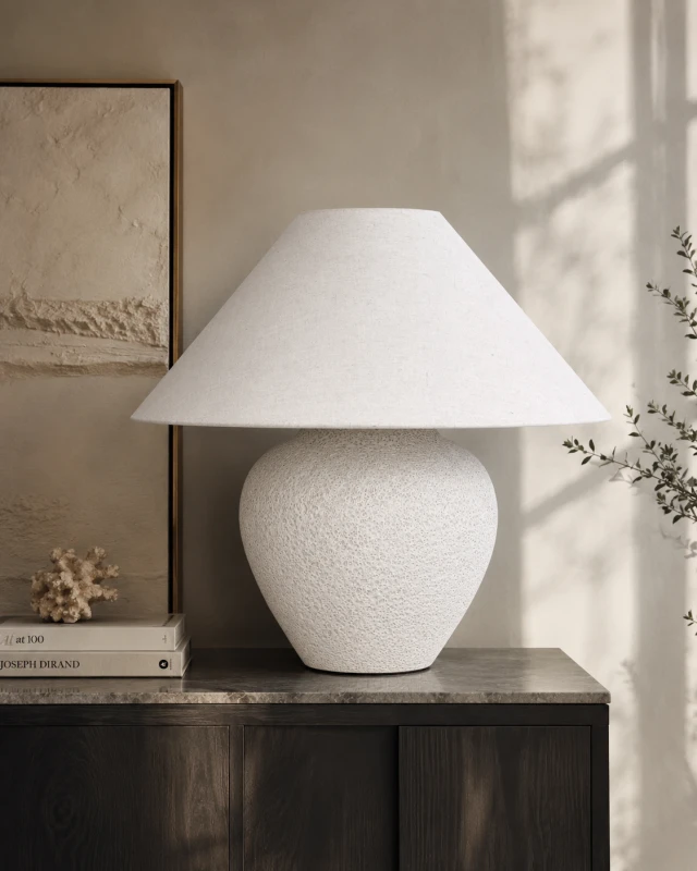 White ceramic table lamp with textured base and wide linen shade