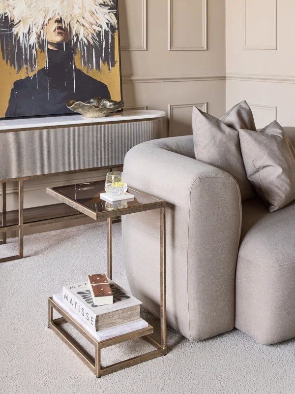 Alice marble and smoked glass side table beside a sofa in an elegant living room