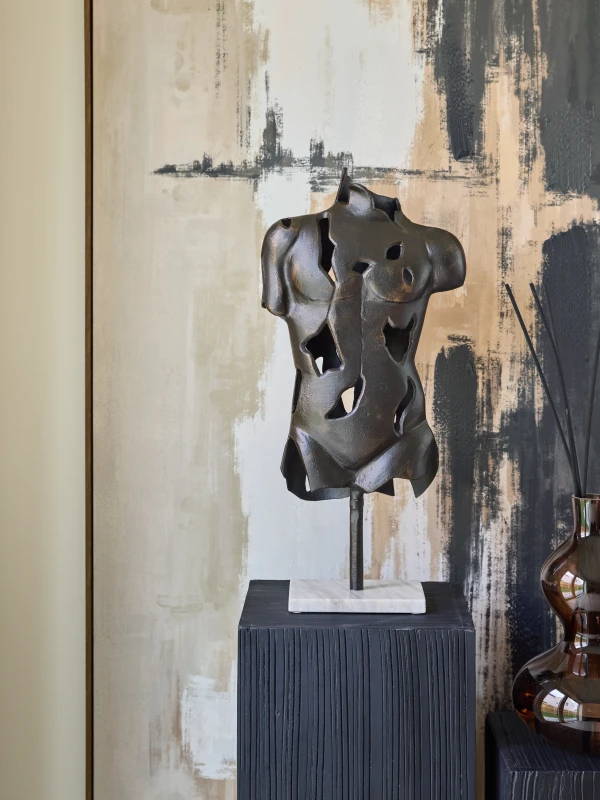 Chelsea Torso sculpture styled on a black pedestal in a contemporary interior