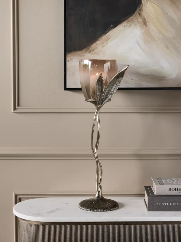 Tall glass hurricane candle holder styled on a luxury sideboard
