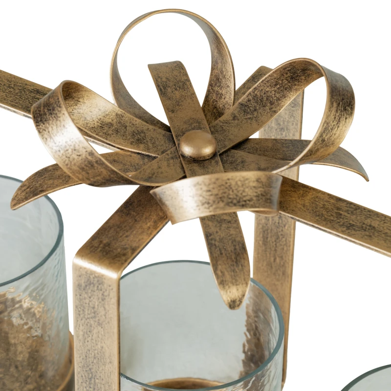 Sculptural bow detail on aged gold candle holder